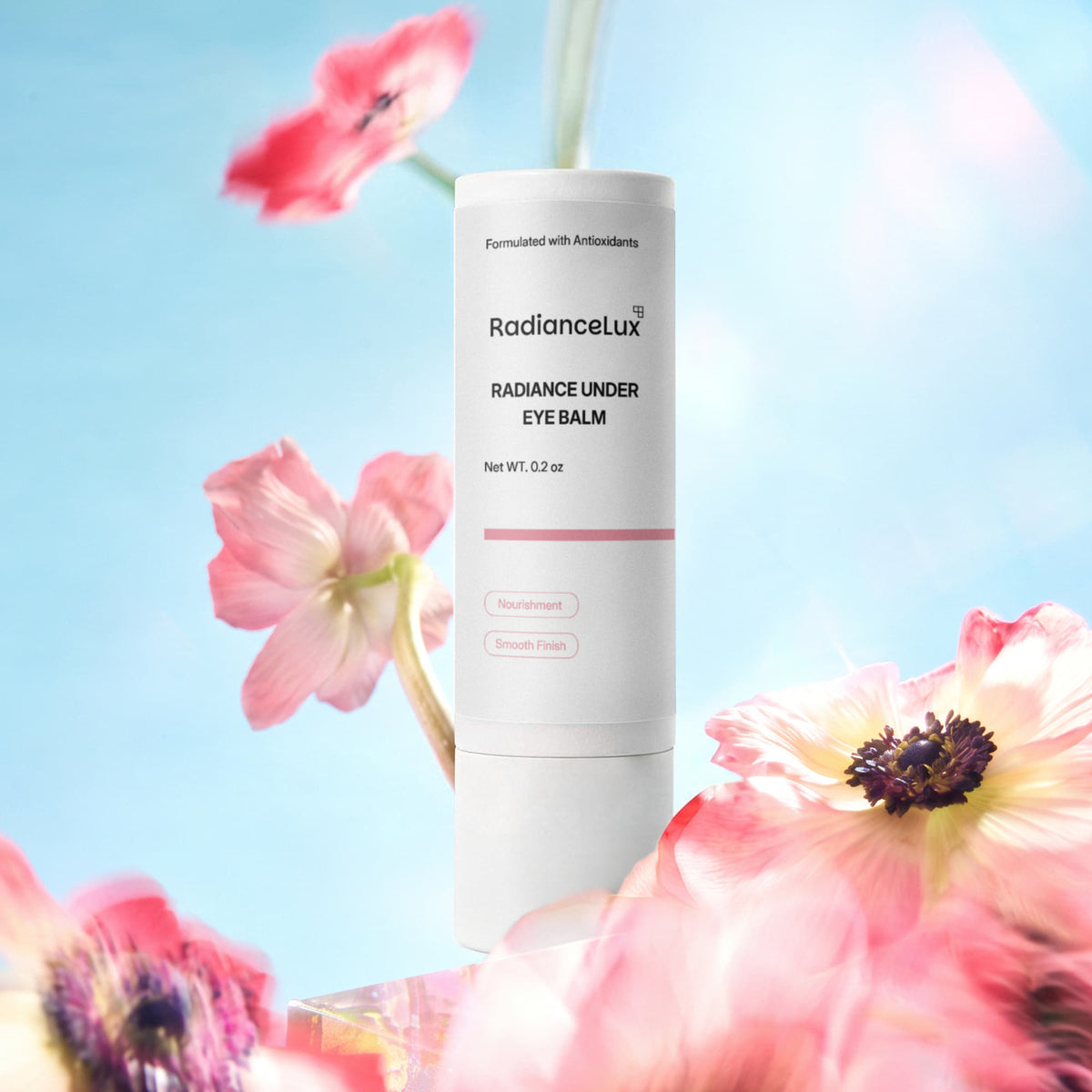 Radiance Under Eye Balm stick among pink flowers against a blue sky