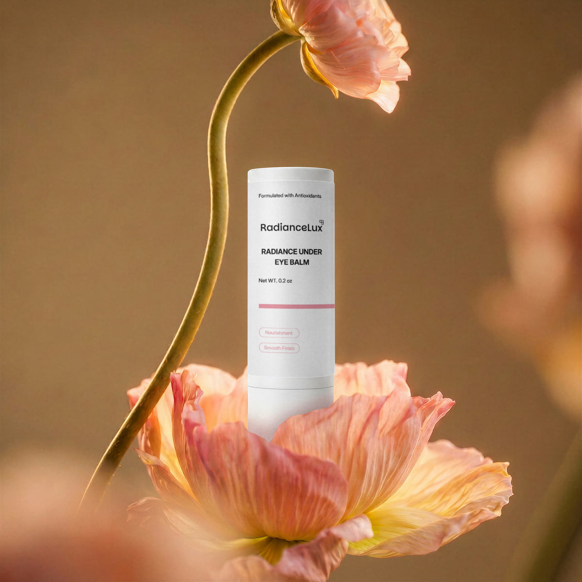Radiance Under Eye Balm stick behind a peach poppy bloom on a golden-brown background